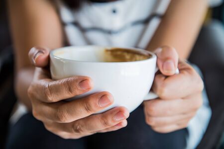 Focus hands holding coffee cups and other soft focus.の写真素材