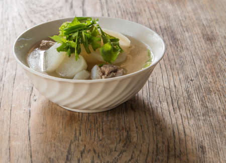 Pork soup with radish laying on a wooden background blur and poor light.の写真素材