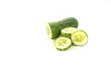 Cut cucumber stacked on a white background.
