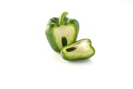Green bell peppers, cut in half on a white background.の写真素材