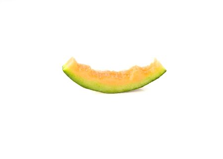 Melon orange slices with bite marks on white background.の写真素材