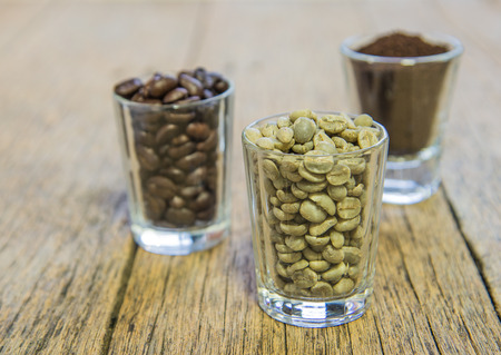 Fresh coffee beans,roasted coffee beans,ground coffee in glass.place on wooden floor.focus front.の写真素材