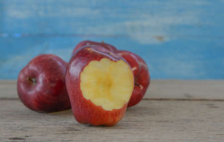 Tree Red Apples placed on wooden floor.Focus bite the apple.の写真素材