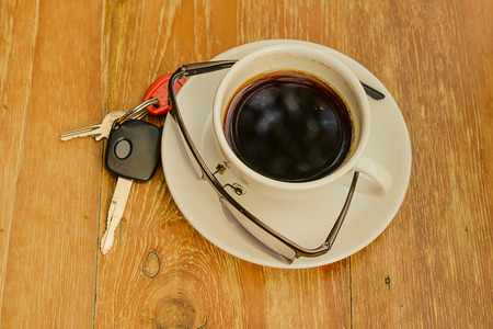 Hot coffee in cup,Key,Eyeglasses placed on wooden floor.focud cup.の写真素材