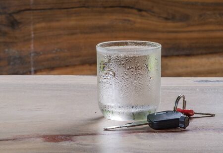 Glass cold water,Car Key placed on wooden floor.focus grass.の写真素材