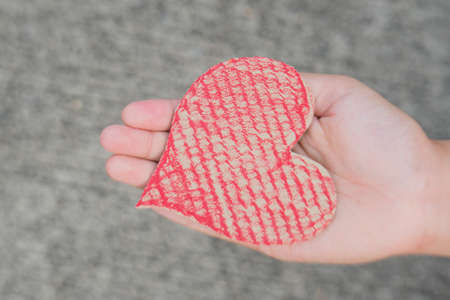 Giving and Take Red Crate paper heart by hand.Focus on Heart.