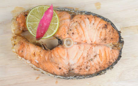 Salmon steaks placed on wooden Cutting Board.
