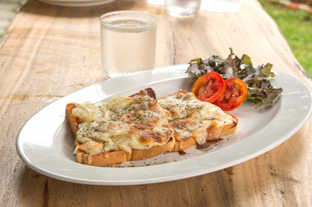 Pizza Toast,Glass of water placed on wooden table.の写真素材