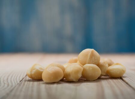 Macadamia on wooden floor with blue wooden background blur.Focus on macadamia.の写真素材