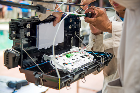 Technicians are install cabinet on fiber optic cable.Blur images with back lighting.