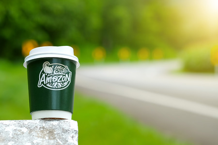 CHIANGMAI, Thailand - September 7, 2016 : Amazon take away coffee cup on concrete road with blurred road background.のeditorial素材