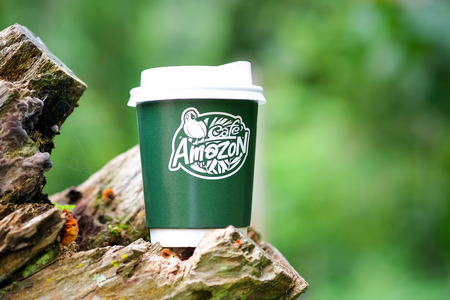 CHIANGMAI, Thailand - September 7, 2016 : Amazon take away coffee cup on wooden with blurred green background.のeditorial素材