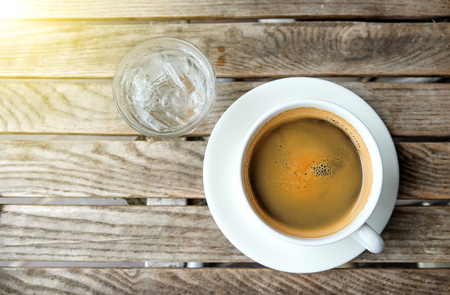 white coffee cup  and glass water on wooden table.Top view focus.の写真素材