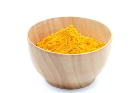 Turmeric powder in woodbowl on white background.の写真素材