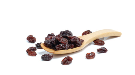 Dried grapes in wood spoon on white background.の写真素材