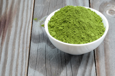 Tea powder in white on wooden floor.