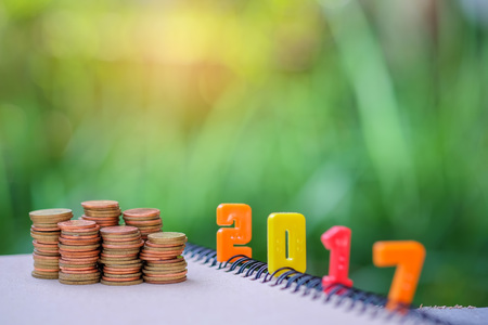2017 text number with coins on blurred background.