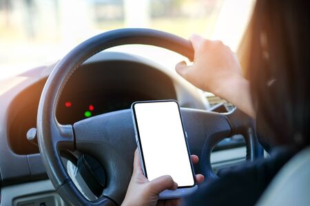 Woman using smartphone while driving a car.の写真素材