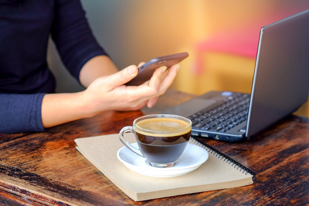 Business people working smart phone with coffee on notebook place on the table.の写真素材