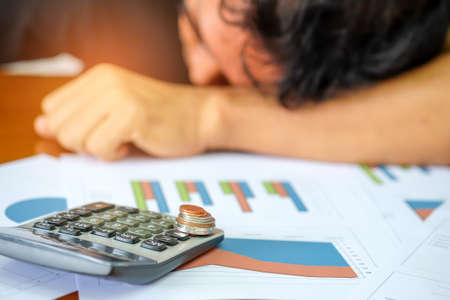 Men are using a calculator to analyze income data.Men make a stressful.