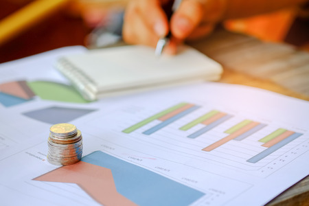 Concept business,Coins and notebooks placed on the graph.の写真素材