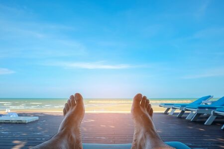 Travel concept,Men's feet on the beach bed with sea background.の写真素材