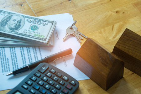 Real estate concepts,Document agreement, model house with dollar bill and calculator.