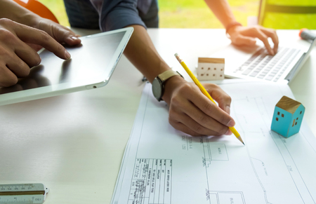 Engineers are designing houses,Engineers are using a home design tablet and another engineer is writing home.の写真素材