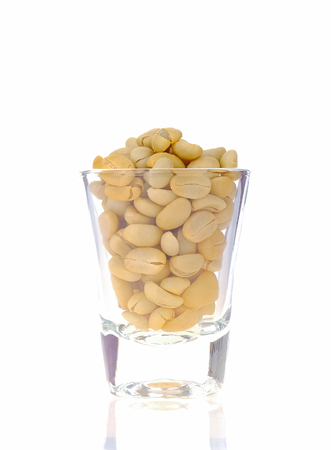 Raw coffee beans in glass on white background.の写真素材