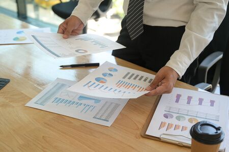 The management is checking the accuracy of the company budget information.He holds the graph in both...
