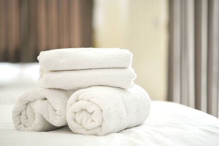Folded white towels placed on the bed in the room.の写真素材