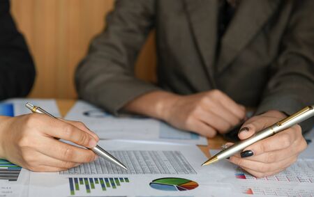 The female accountant team is calculating the budget to present executives.They use the pen to point...