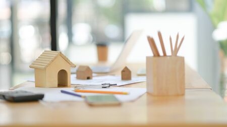 Mockup house drawing tools and wooden model house on desk in the office.の写真素材