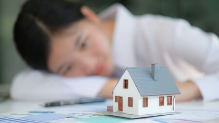 Real estate concept, Front model house with girl in the background look at home.She dreamed of buying a house.の写真素材