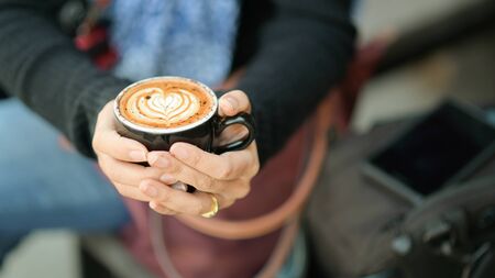Coffee latte heart texture in hand of tourists.の写真素材