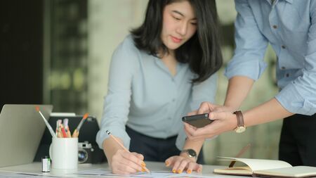 Cropped shot of A team of professional designers are working with smartphone and laptops to design applications.の写真素材