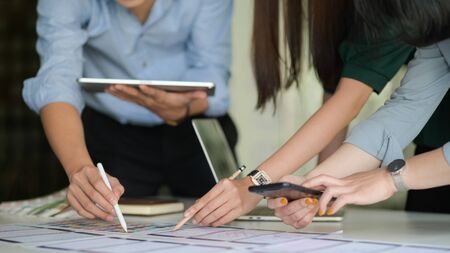 The UX team is designing an application for smartphones with a laptop in a modern office.