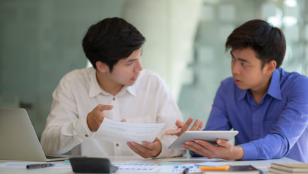 Professional team with laptop and tablet consult new projects for presentation to executives.の写真素材