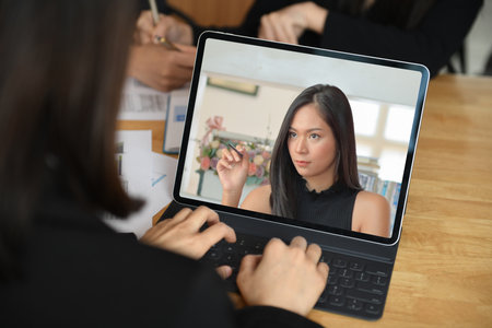 Two young female students with coffee are using a laptop to study online at home in the summer semester,Work at home,Work from home.の写真素材