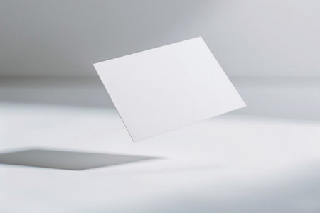 Detailed close-up of a business card mockup hovering over a white paper background, contemporary designの素材