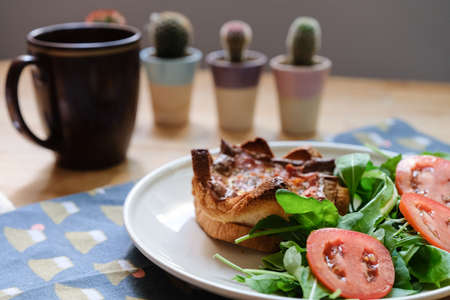 Bread, sprinkled with ham and sheet, put in the oven and served with salad, eaten at home in the...
