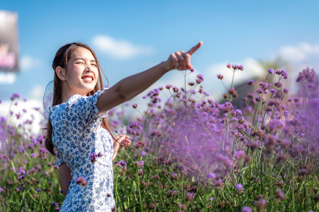 Portrait of a cheerful Asian Thai woman in a purple flower garden.の写真素材