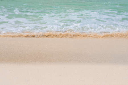 Beautiful soft green ocean wave of the sea on the sandy beach. Texture background. Selective focus.