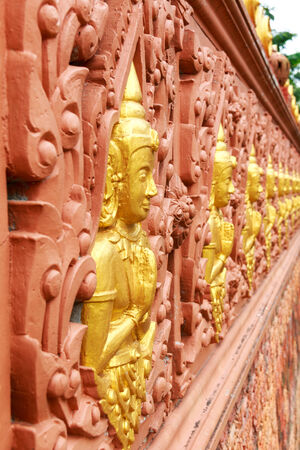 Row of Buddha statues in Buddhist temple wallの写真素材
