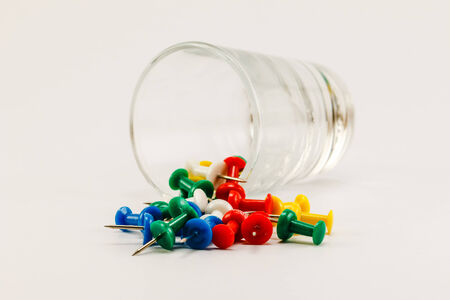 push pins and glass on white backgroundの写真素材