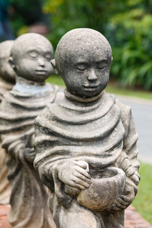close up Statue of monk receive food offeringsの写真素材