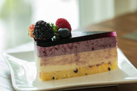 fruit cake with berries on white plateの写真素材