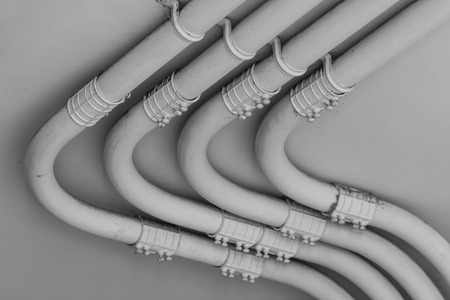 Pipe of electricity line on cement  wall in black and white toneの写真素材