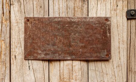 Rusty steel Label on woodの写真素材
