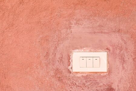 Old Switch on orange cement wallの写真素材
